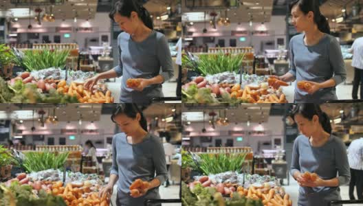 漂亮的女人在超市买胡萝卜蔬菜和水果高清在线视频素材下载