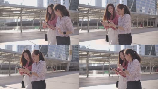 两位亚洲女商人在上班路上使用智能手机高清在线视频素材下载