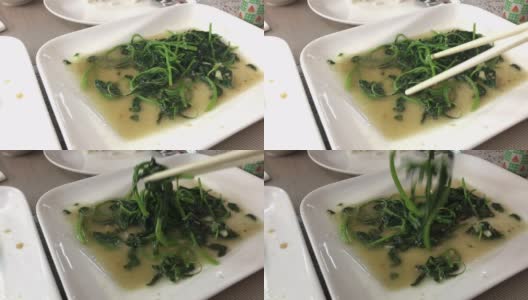 用筷子夹起绿色蔬菜，中国食物用油高清在线视频素材下载