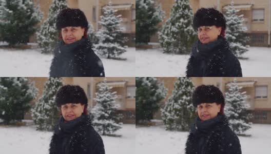 美丽的高级女人戴着冬天的帽子和花时间在户外而下雪高清在线视频素材下载
