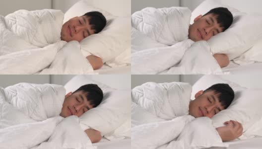 快乐的亚洲年轻人早上睡在舒适的床上。高清在线视频素材下载