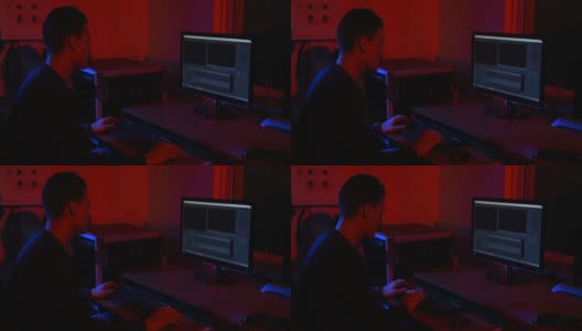 Man视频编辑工作在电脑上的素材。用于视频编辑的程序。霓虹灯。高清在线视频素材下载