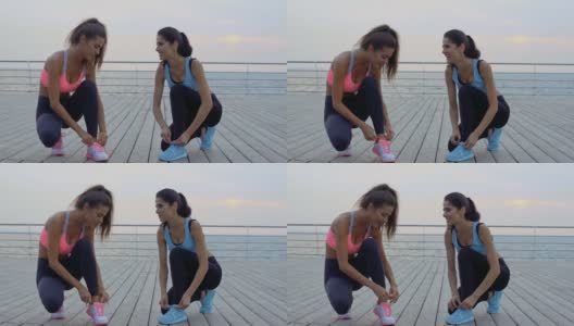 两名年轻的女运动员为跑步系鞋带高清在线视频素材下载