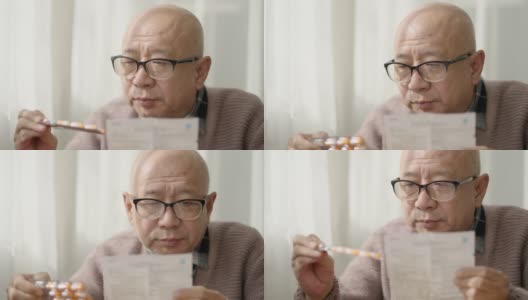 一位中国老人坐在窗边，戴着老花镜，阅读说明书高清在线视频素材下载