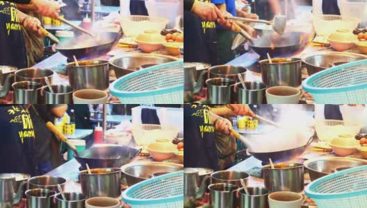 在泰国曼谷唐人街做街边小吃。在平底锅里炒面条，火和火焰下它高清在线视频素材下载
