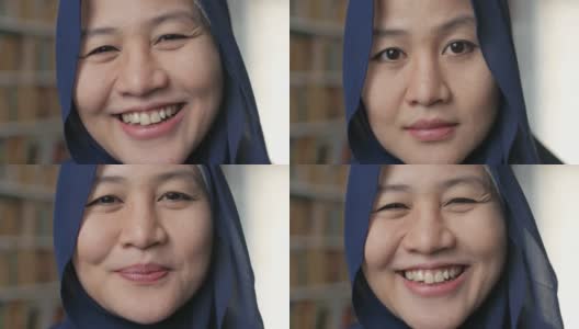 快乐美丽的亚洲穆斯林妇女戴着头巾对着镜头微笑，女学生在图书馆高清在线视频素材下载