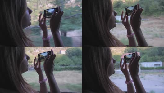旅行中的女人在公交车上，用智能手机拍摄风景高清在线视频素材下载