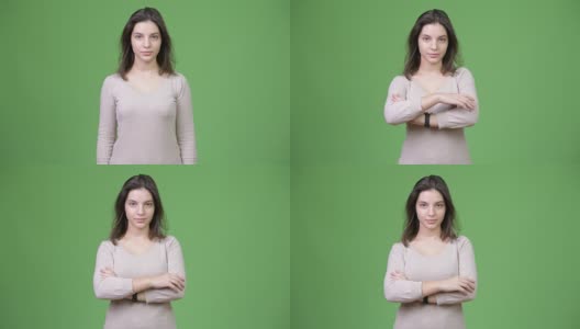 年轻美丽的女人双臂交叉在绿色的背景下高清在线视频素材下载