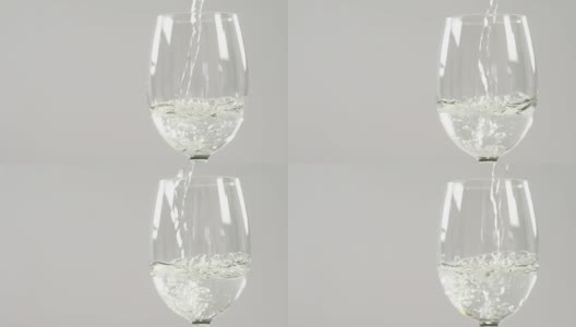 白葡萄酒在白色背景下落在玻璃杯中高清在线视频素材下载