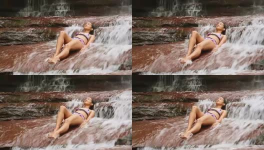 性感的女孩与比基尼躺在瀑布河高清在线视频素材下载
