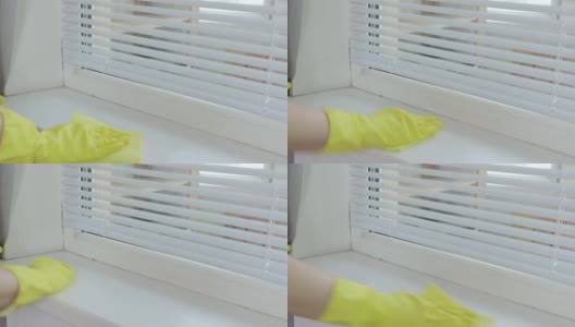 一个戴着黄色橡胶手套的女人用抹布擦拭窗台高清在线视频素材下载