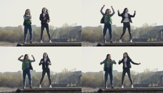 两个快乐美丽的亚洲少女在街上跳舞。高清在线视频素材下载