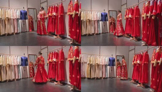 美丽的年轻新娘在红色和金色的婚礼群瓜在设计师商店高清在线视频素材下载