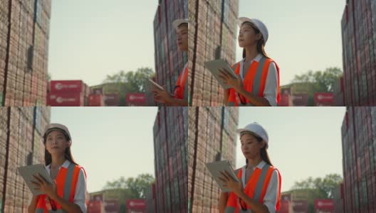 亚洲工程师领班女工人在集装箱货港进行检查，用压片装置装载货物集装箱。码头女工物流进出口船坞概念。高清在线视频素材下载