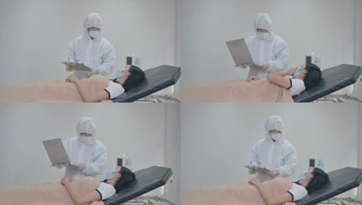 亚洲男性医生在隔离病房的病床上检查流感患者的症状并在检查表上写下信息高清在线视频素材下载