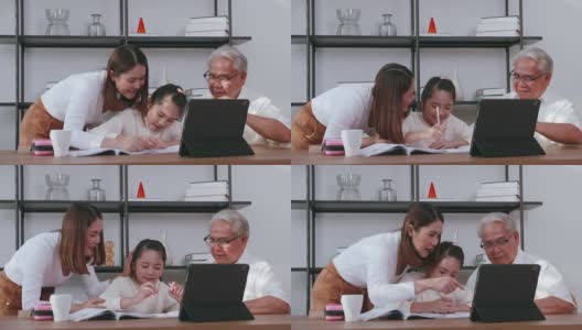 爷爷和妈妈一边教女儿做作业，一边在家上网学习。高清在线视频素材下载