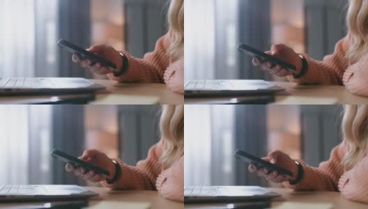 一名女性在家工作时使用智能手机的4k视频片段高清在线视频素材下载