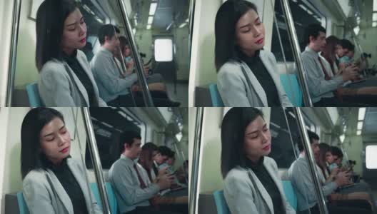一个亚洲女人坐在地铁里。乘坐公共交通，她又累又沮丧高清在线视频素材下载