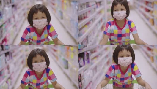 一个亚洲小女孩戴着口罩在当地的超市里走着，看着货架上的产品。高清在线视频素材下载