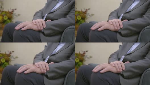 一个穿着西装的已婚男子抱着双臂坐在膝盖上高清在线视频素材下载