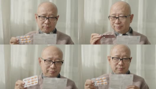 一位中国老人坐在窗边，戴着老花镜，阅读说明书高清在线视频素材下载