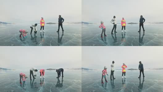 一家人在大自然的冰上进行体育锻炼。父亲在冬天训练他的家人。母女和儿子看着他的训练课。孩子们试着重复。运动前的标准拉伸。高清在线视频素材下载