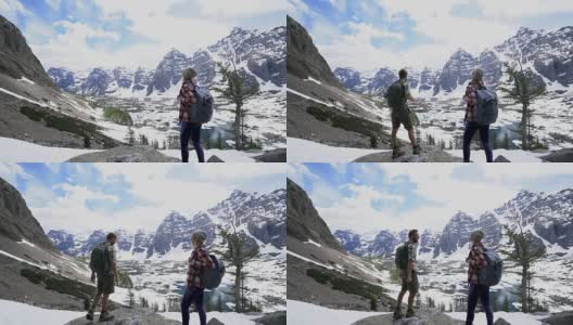 一对在加拿大落基山脉徒步旅行的夫妇到达山顶并击掌庆祝高清在线视频素材下载