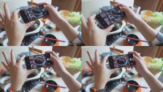 白天，在一家餐馆里，一位女士的手正在用智能手机拍摄日本火锅高清在线视频素材下载