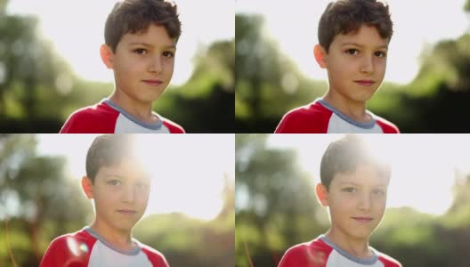 一个小男孩在美丽的白天站在外面的肖像。英俊的孩子的脸高清在线视频素材下载