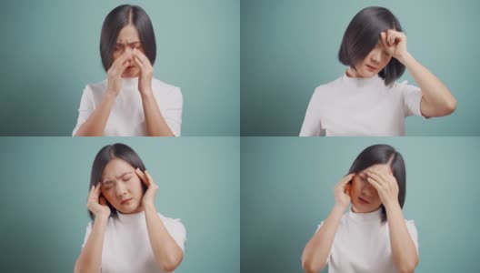 一名亚洲女性患有头痛偏头痛，孤立地站在蓝色背景上。卫生保健的概念。4 k的视频。高清在线视频素材下载