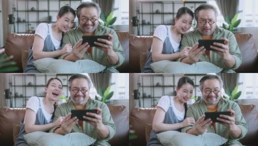 离开的亚洲夫妇在家里客厅的沙发沙发上一起玩智能手机在线移动游戏，周末的休闲居家隔离生活方式居家室内背景高清在线视频素材下载