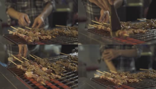 一位香港厨师在烤架上翻转烤肉串并涂上酱汁高清在线视频素材下载
