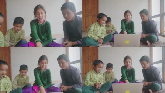 一个小女孩正在教一群印度亚裔小学的孩子们在室内用笔记本电脑一起学习高清在线视频素材下载