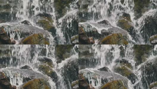 巨大的黑色巨石上有水从山上流出的透明溪流高清在线视频素材下载