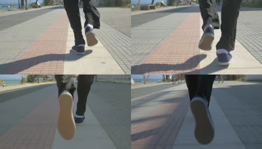 男人们的脚在度假小镇的人行道上奔跑高清在线视频素材下载