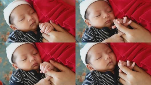 妈妈用手摸着睡着的宝宝的手高清在线视频素材下载