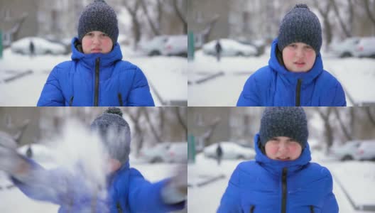 穿着蓝色羽绒服的少年扔雪。冬天，飘落的雪，特写高清在线视频素材下载