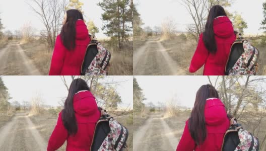 年轻女子走在人行道上。春日里，背着五颜六色背包的年轻女子走在乡间小路上的背影高清在线视频素材下载