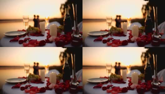 日落时分，一对情侣在海滩餐厅浪漫约会高清在线视频素材下载