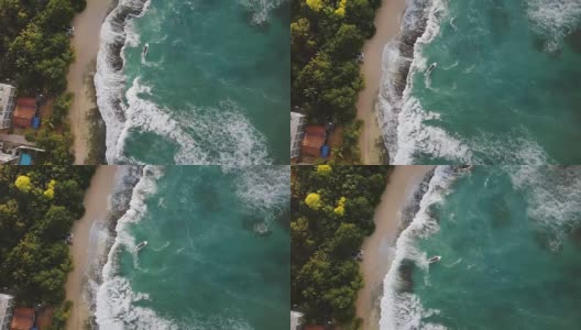 无人机在空中拍摄的田园诗般的异国海滨，小船，白色的浪花和度假屋高清在线视频素材下载