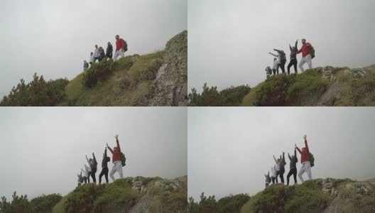 一群快乐的登山者在山顶举起双手的成功团队理念高清在线视频素材下载