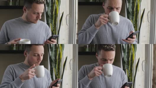 一个年轻人早上在窗口边喝着咖啡边用手机聊天高清在线视频素材下载