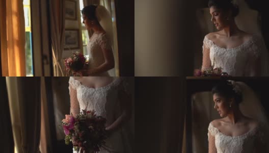 新娘手持花束，在婚礼前透过窗户看高清在线视频素材下载