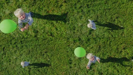SLO MO CS金发小男孩在阳光明媚的草地上放飞气球高清在线视频素材下载