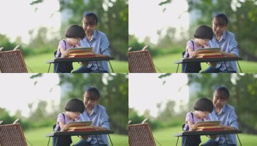 亚洲小女孩与年轻的妈妈在花园里学习，击掌，成功高清在线视频素材下载