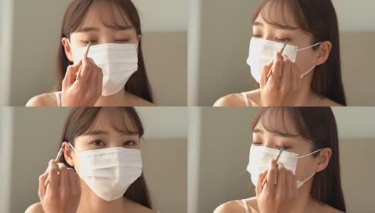 年轻的亚洲女人戴着面具化妆高清在线视频素材下载
