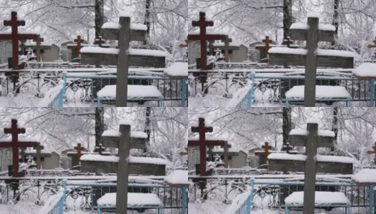 在冬天以慢动作拍摄的墓地上被雪覆盖的十字架的特写镜头高清在线视频素材下载