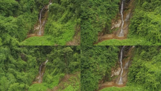 鸟瞰图小瀑布流经常绿森林的岩石悬崖。泰国北部高清在线视频素材下载