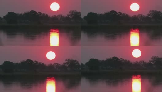 红色和金色的日落在非洲的河上，太阳穿过金色的水道在水上高清在线视频素材下载