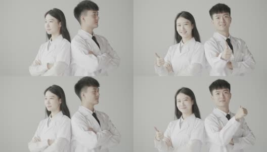 美丽的女医生和男医生背靠背站着，对着镜头微笑，亚洲医生，整形医生，慢动作拍摄高清在线视频素材下载